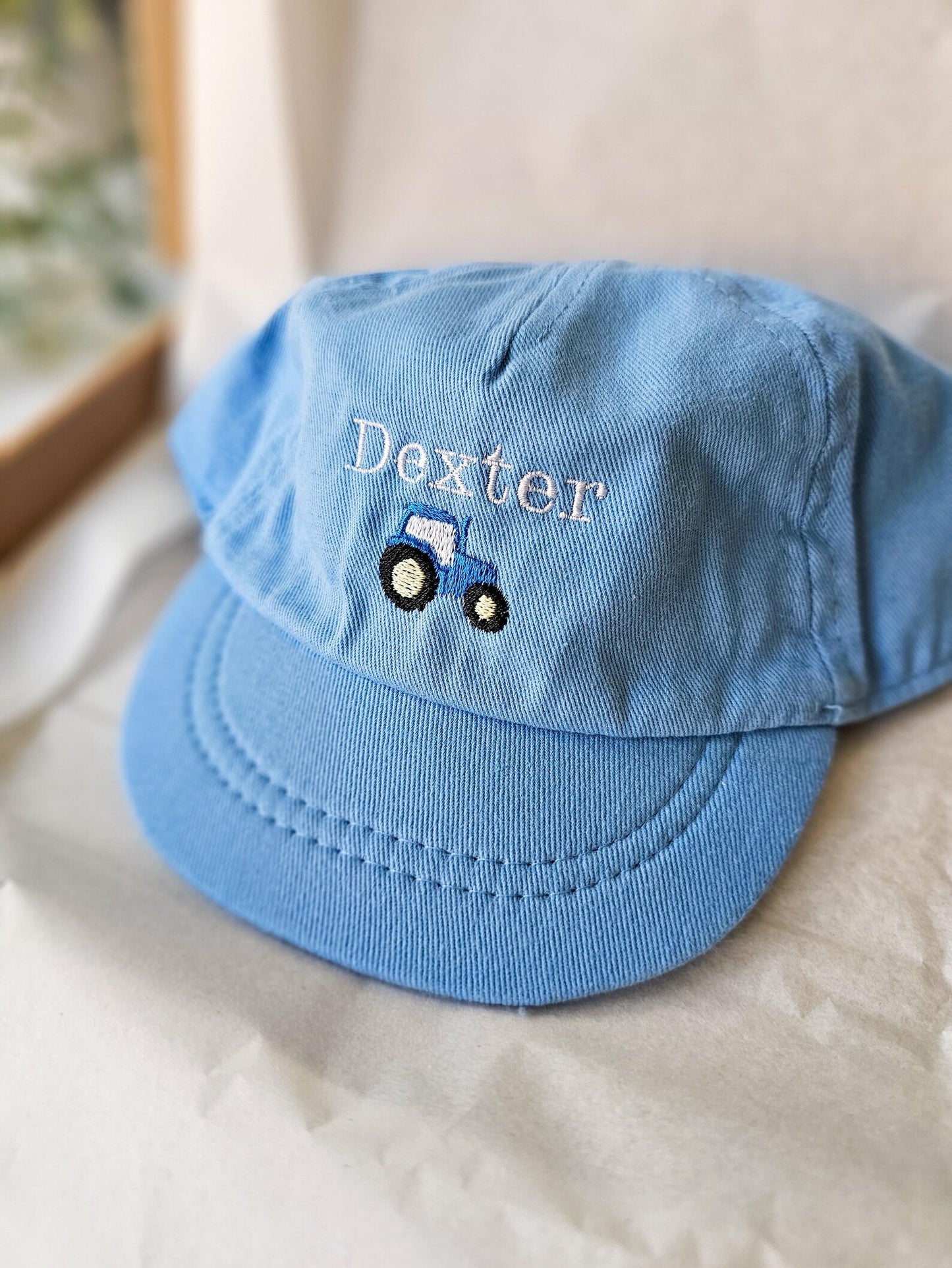 personalised and embroidered Blue cap with 'Dexter' and a tractor design on a light background