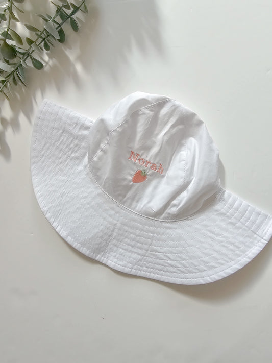 White children/toddler wide brimmed sun hat personalised with childs name and cute pink strawberry design embroidered.