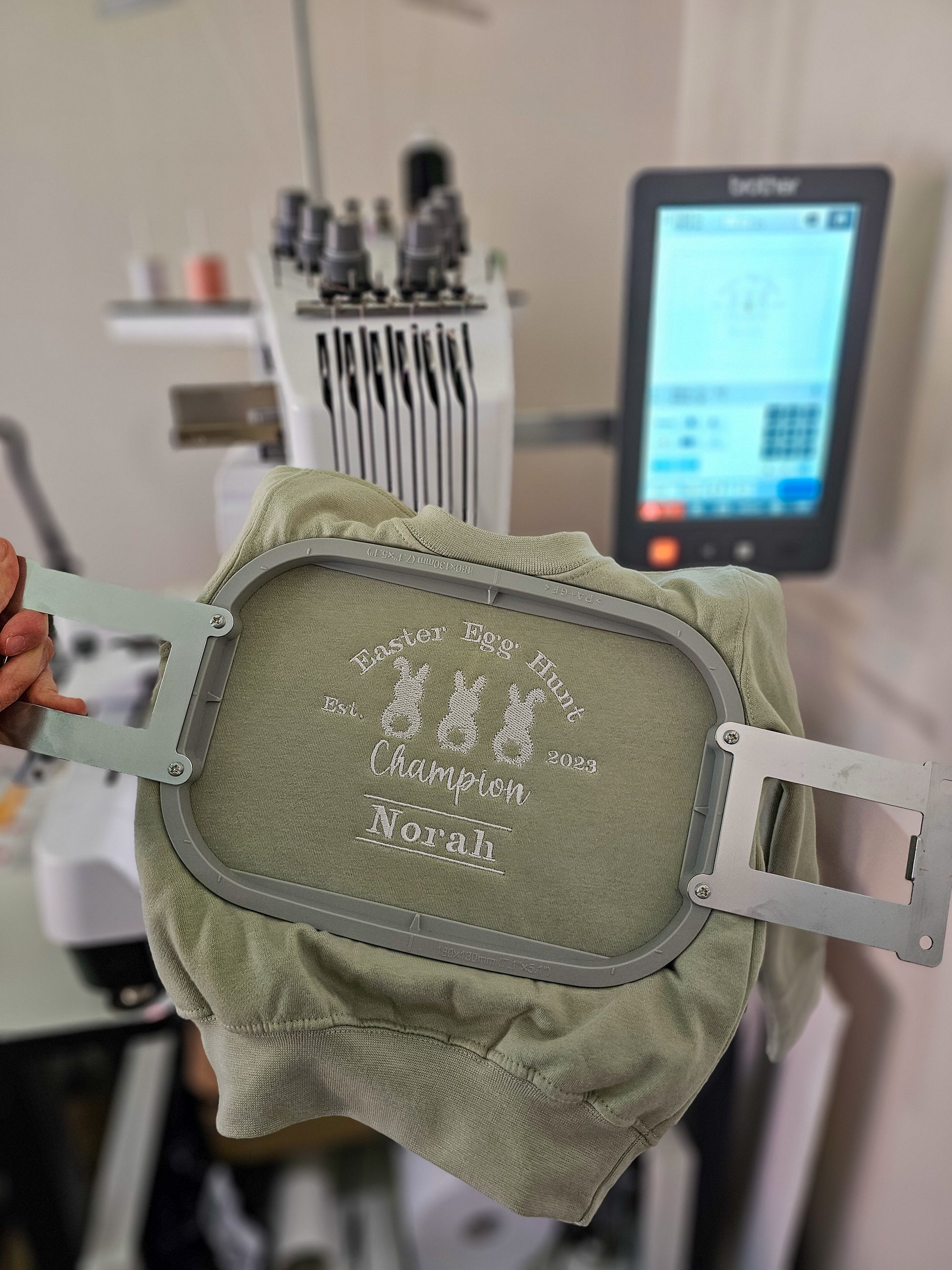 Personalised sage green children’s Easter jumper embroidered with Easter Egg Hunt Champion design and child’s name.