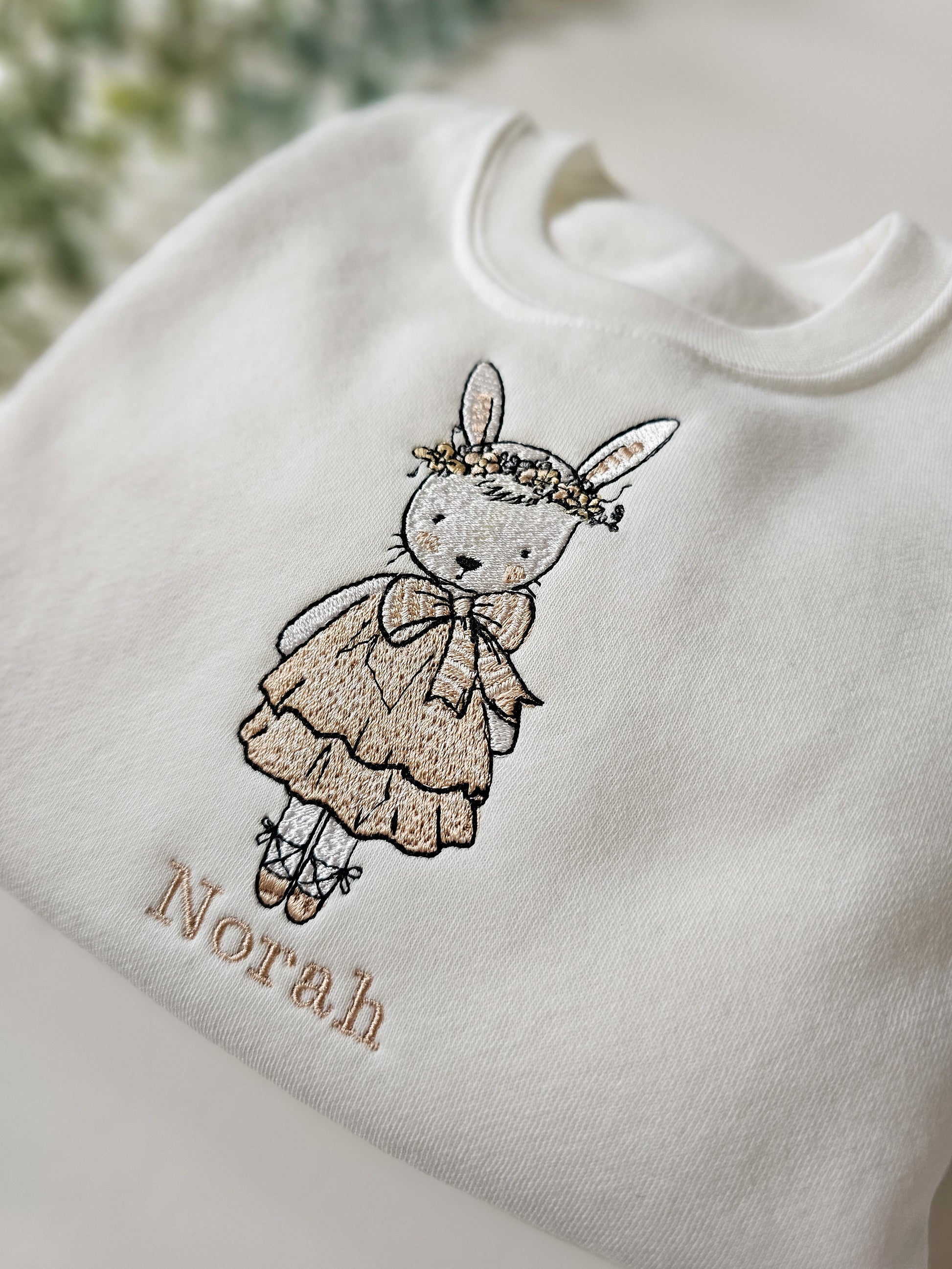 Personalised white children’s jumper with embroidered bunny wearing pink dress and floral flower crown with child’s name