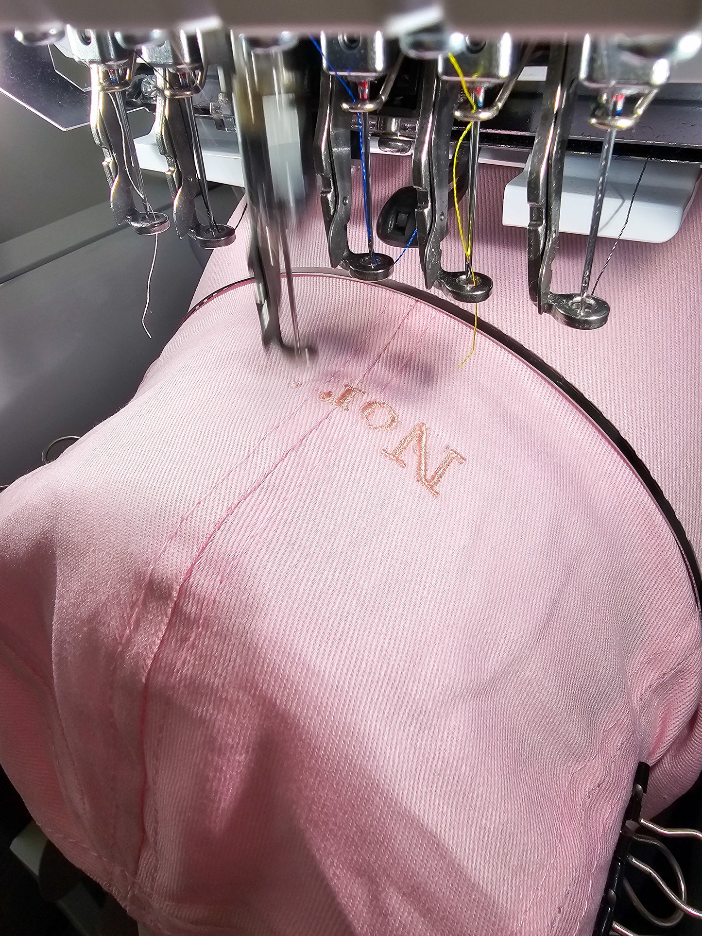 pink coloured children/toddler/baby personalised embroidered cap. Being sewn on the machine.
