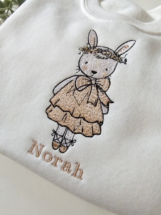 Personalised white children’s jumper with embroidered bunny wearing pink dress and floral flower crown with child’s name