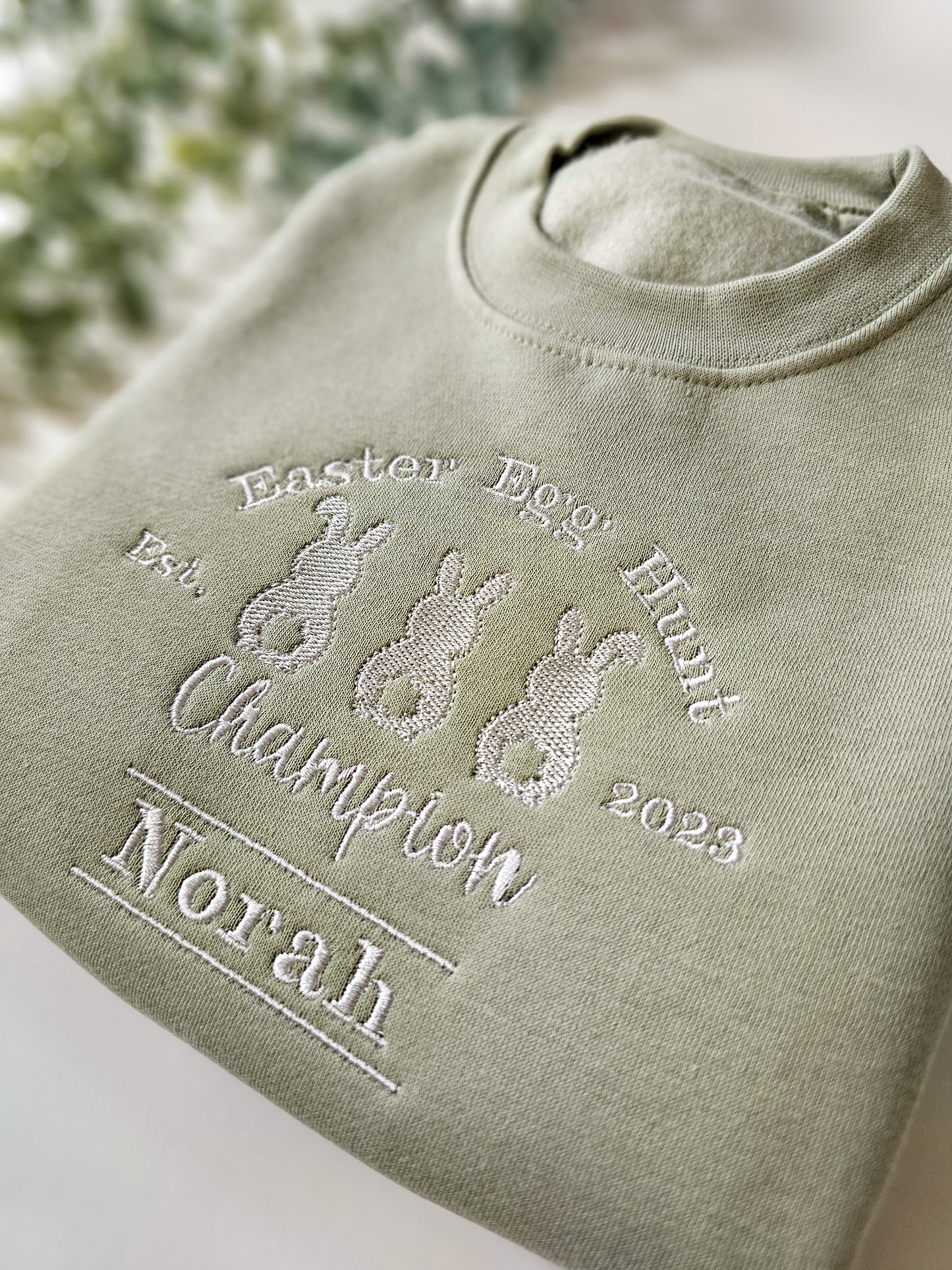 Personalised sage green children’s Easter jumper embroidered with Easter Egg Hunt Champion design and child’s name.