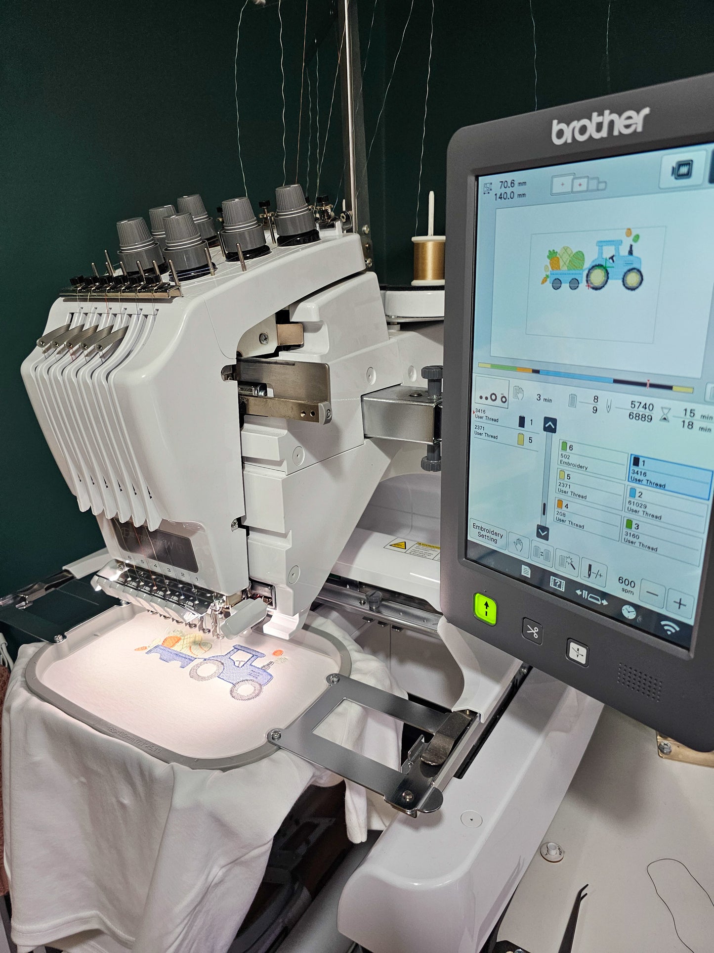 Brother embroidery machine with digital display of an easter themed tractor on a kids tshirt